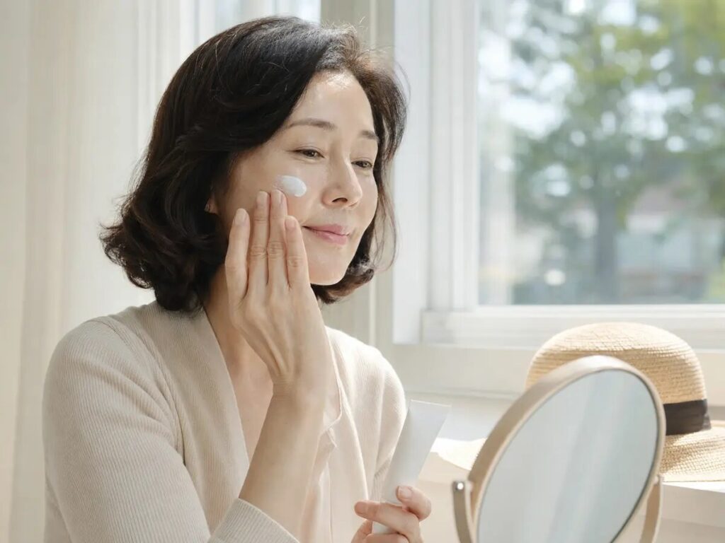 레티놀 사용 다음 날 아침 자외선 차단제를 바르는 50대 여성
