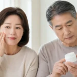 피부 장벽이 무너졌을 때 증상을 살피고 보습제 용기를 확인하는 50대 남녀