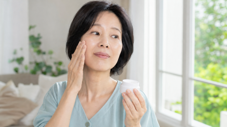 세안 후 볼의 피부 상태를 확인하며 보습크림을 든 50대 한국인 여성