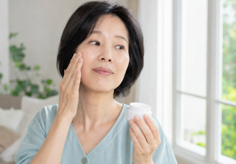 세안 후 볼의 피부 상태를 확인하며 보습크림을 든 50대 한국인 여성