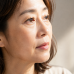 자연광에서 눈가와 볼의 피부결이 보이는 50대 여성 얼굴 클로즈업