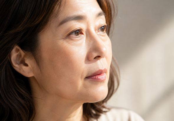 자연광에서 눈가와 볼의 피부결이 보이는 50대 여성 얼굴 클로즈업
