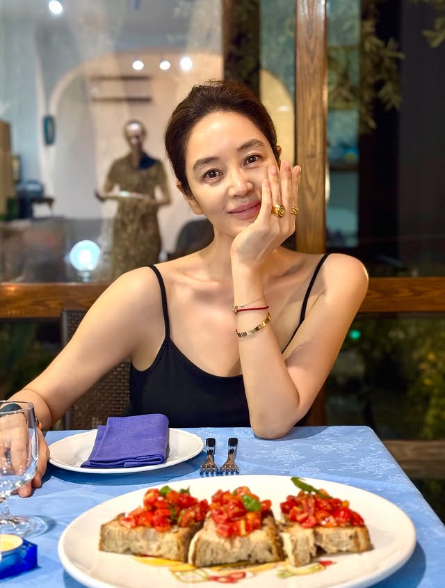 김혜수 짧은 머리를 뒤로 넘기고 검은색 의상을 입은 식사 장면