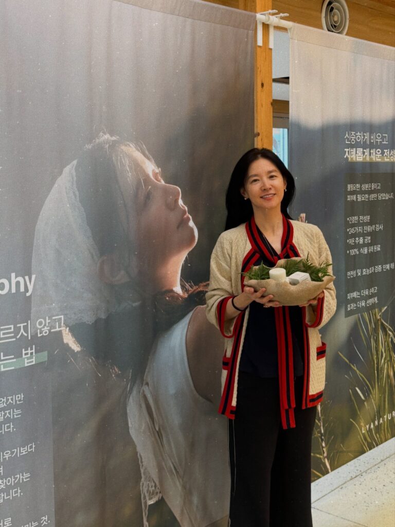 크림색 카디건을 입고 제품 바구니를 든 이영애의 정면 모습